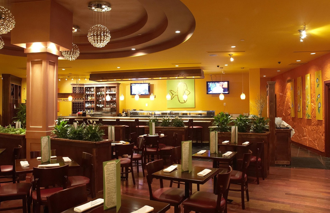 A warmly lit sushi bar with seating along the counter