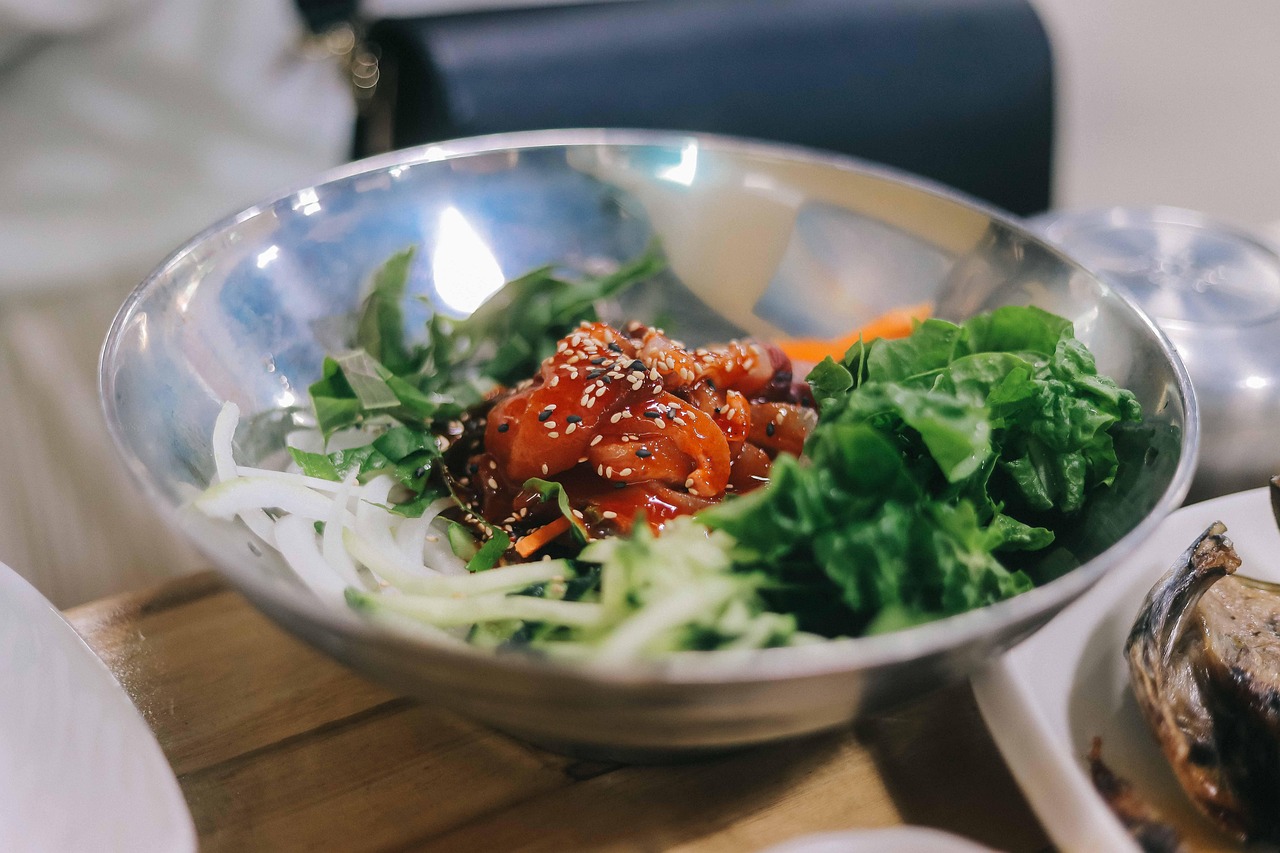 A Korean bibimbap bowl with vegetables and herbs